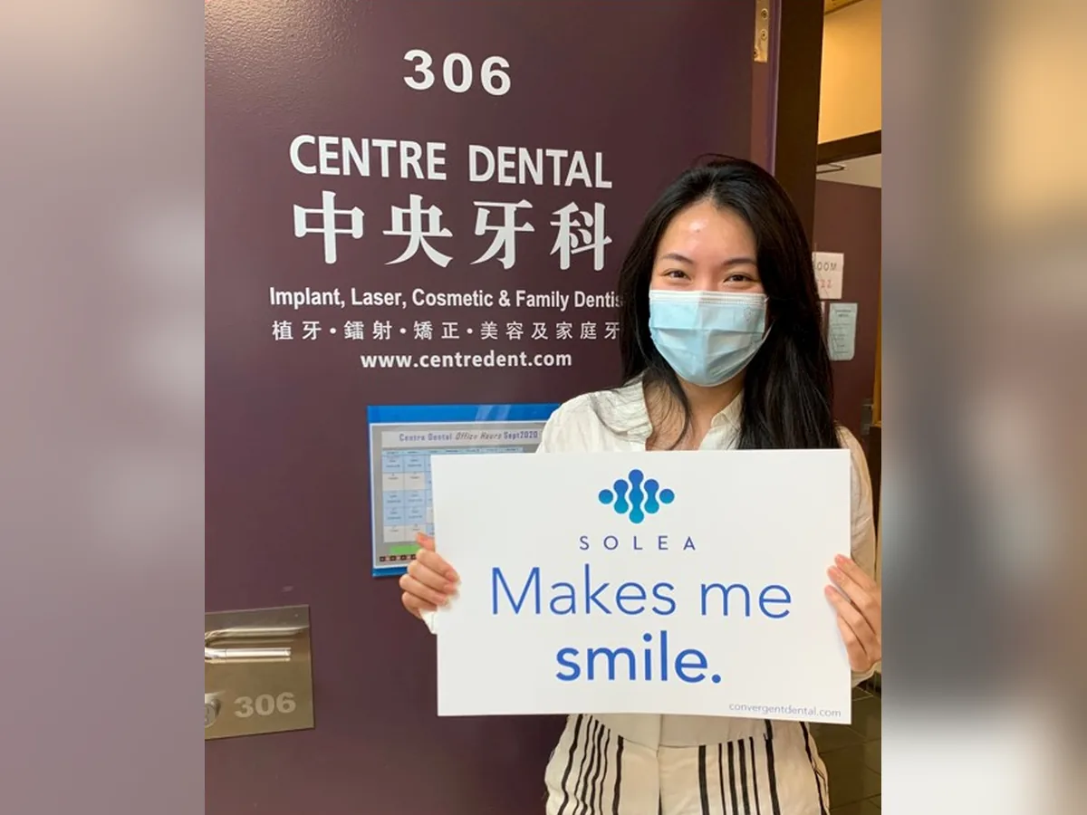 Centre Dental patient holding a "Solea makes me smile" sign after a laser filling without a needle — Centre Dental NYC