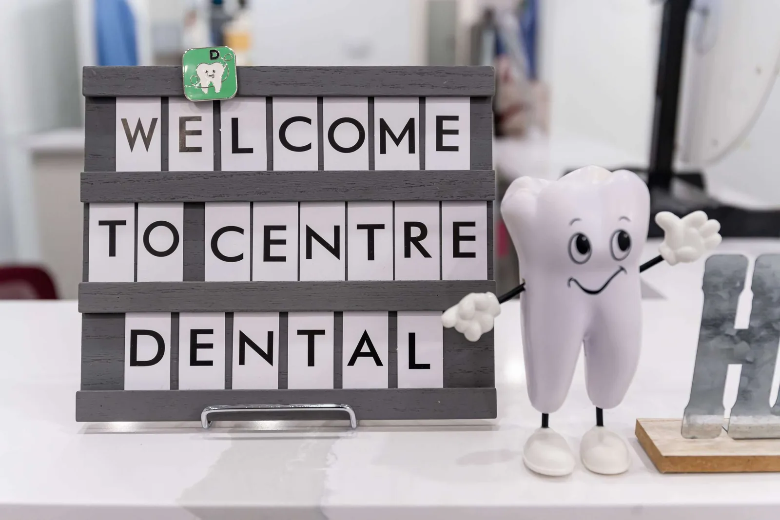 前台「Welcome to Centre Dental」欢迎牌和微笑牙齿公仔